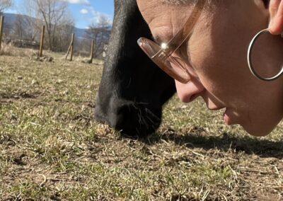 Mujer junto a caballo pastando.